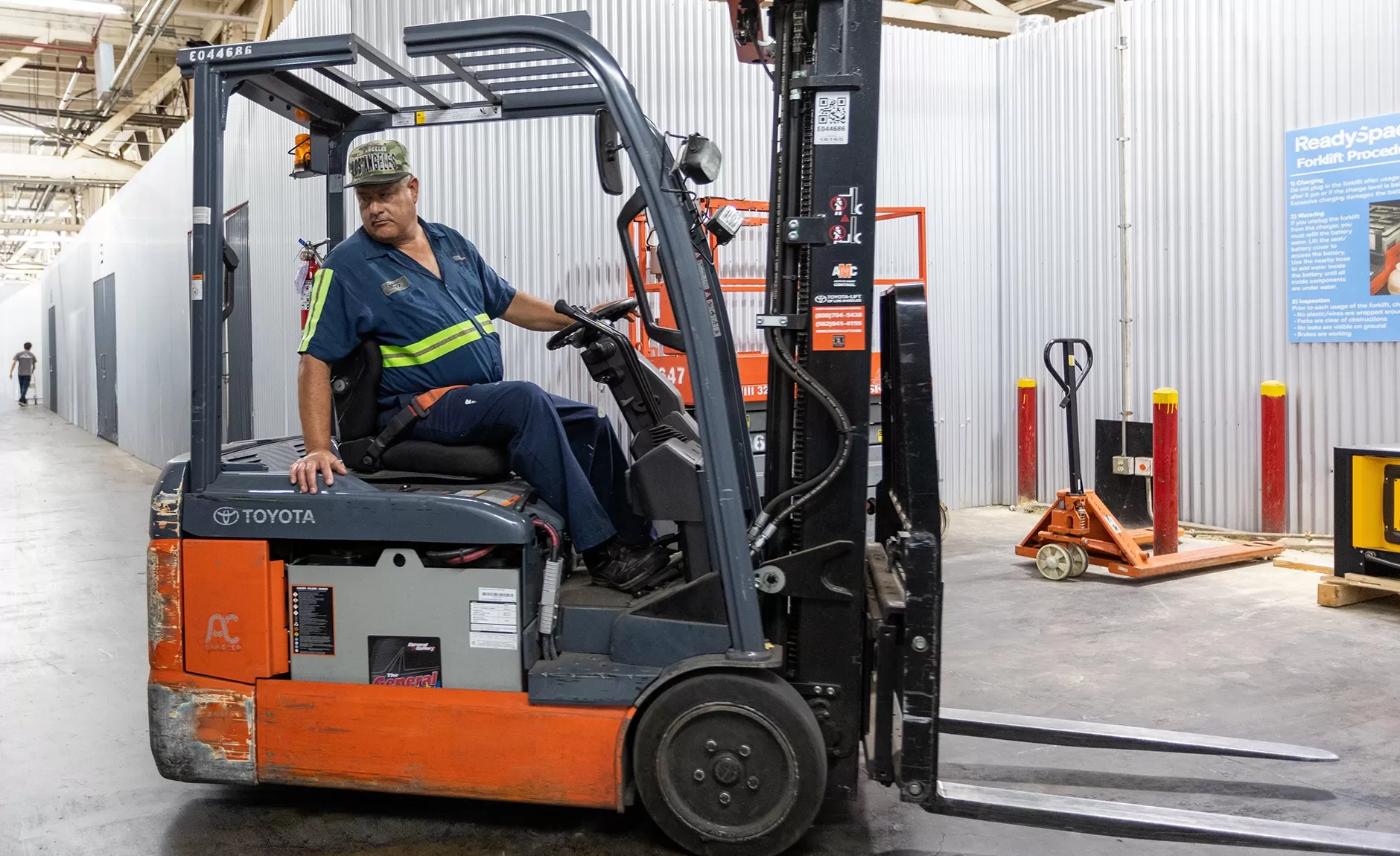 A man on a forklift in a warehouse.