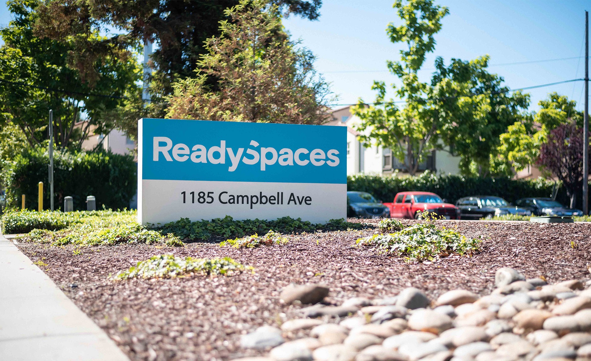 A sign for readyspaces in front of a building.