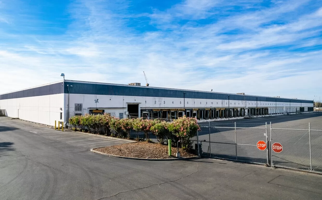 A spacious warehouse in Hayward with a sturdy fence surrounding it.