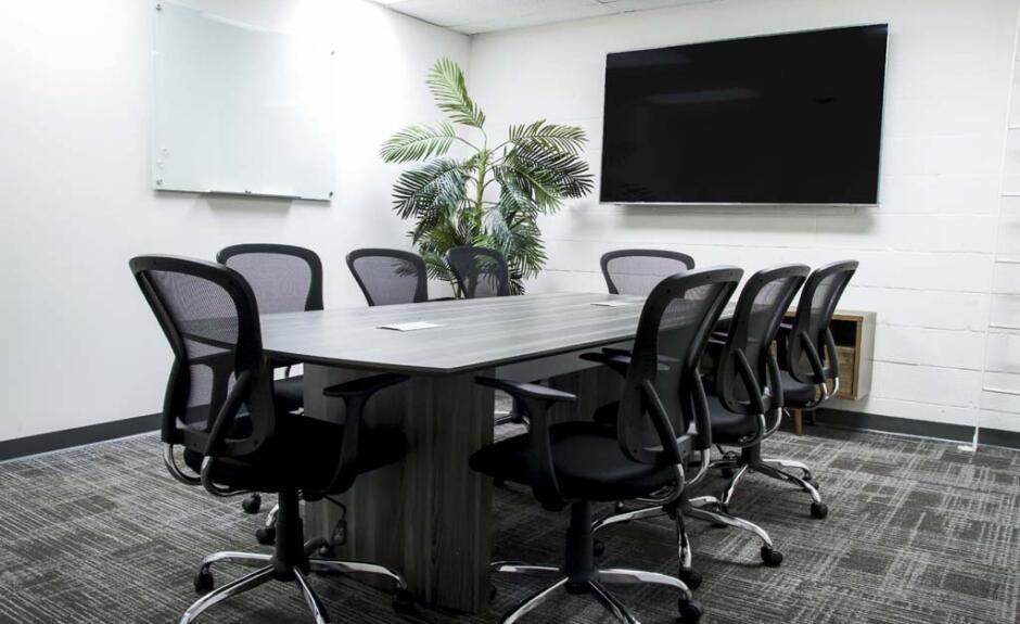 A conference room with a large table and chairs.