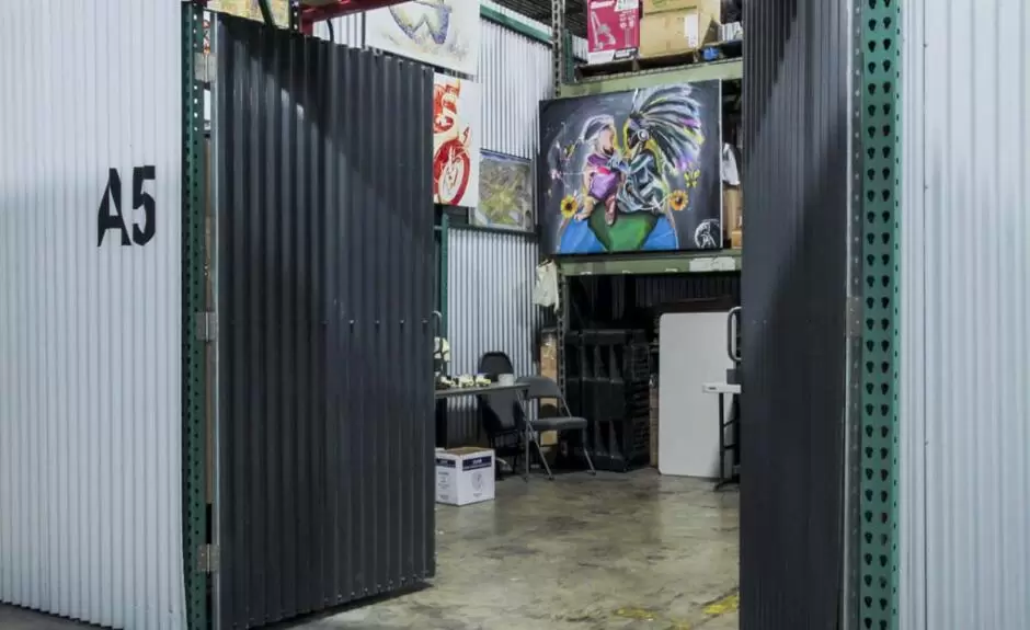 A storage room with a door that opens up to a room full of art.