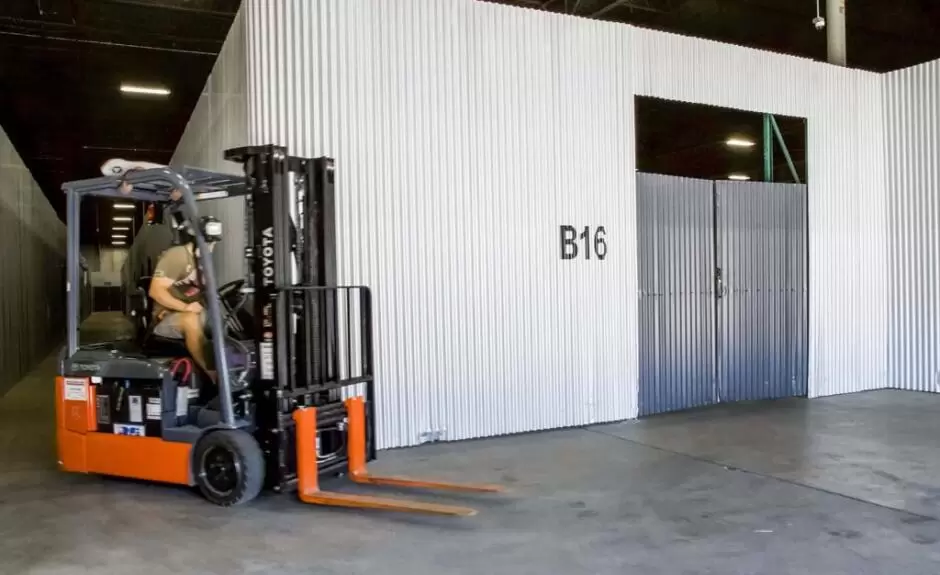 A forklift in a large storage room.