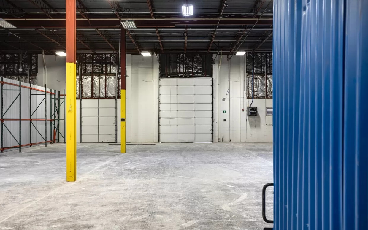 An empty warehouse with blue and yellow walls.