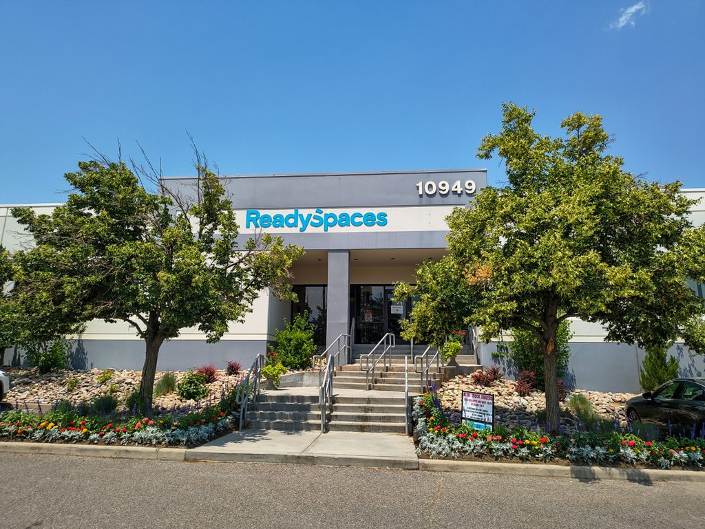Front entrance of ReadySpaces Denver Centennial at 10949 E Peakview Ave, with the ReadySpaces sign above the main doors and landscaped steps out front